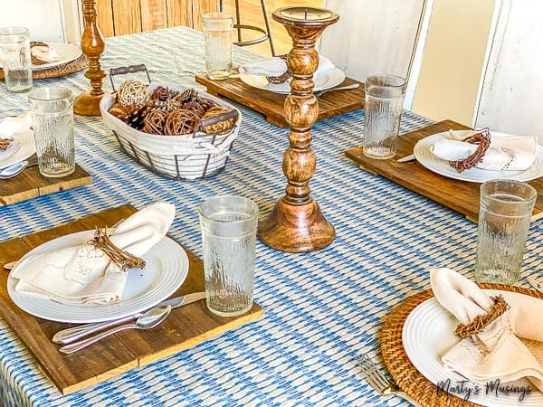 toalha azul usada como caminho de mesa com detalhes em madeira e louça branca