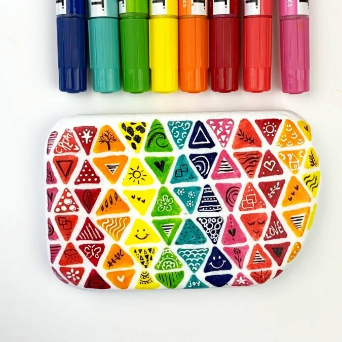 Ideia de Pedra Pintada - Doodle Rock composto por vários triângulos com desenhos individuais sobre eles