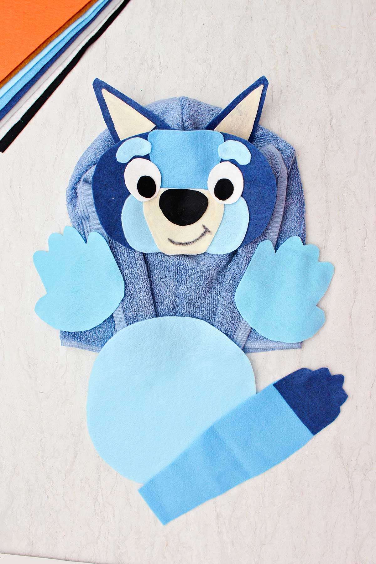 Uma fantasia de Halloween de blue healer feita de feltro e uma toalha de banho azul.