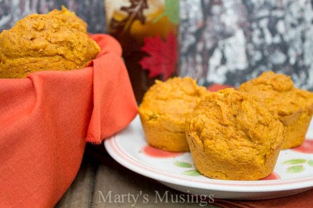 Prato com muffins de abóbora e cesta com um copo de chá
