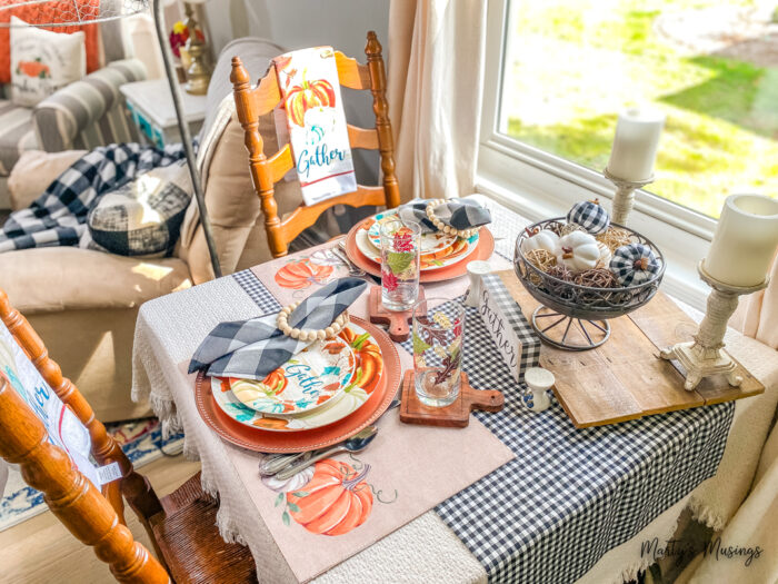 Mesa pequena decorada para o outono com xadrez preto e branco e detalhes em laranja e azul