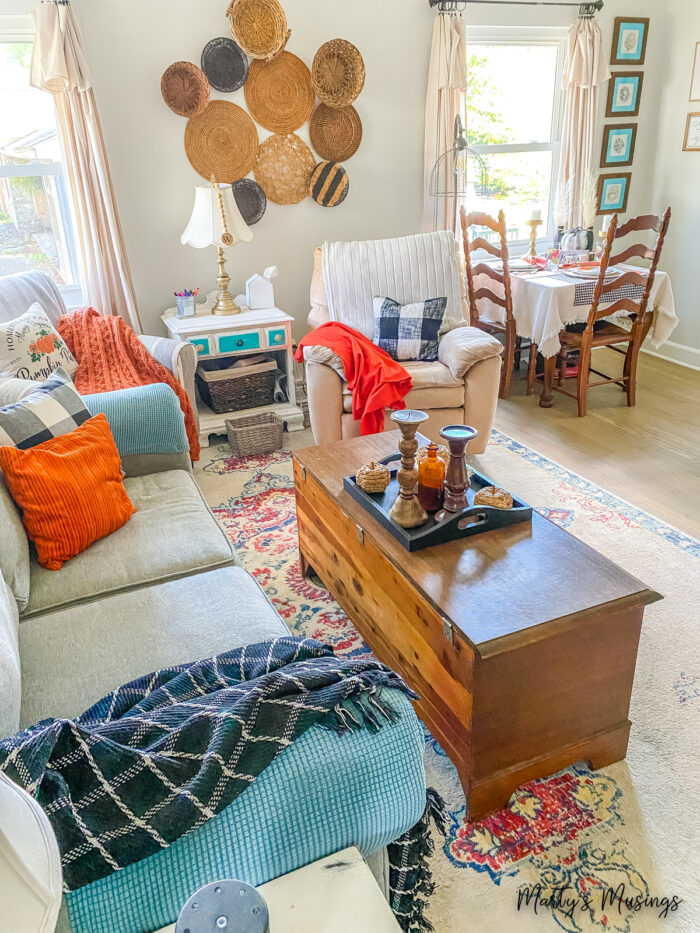 Sala de estar decorada para o outono com detalhes xadrez em laranja e preto