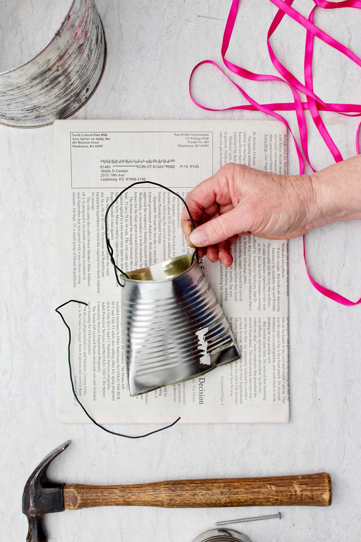 Lata achatada em uma extremidade com fio para pendurar na extremidade aberta.