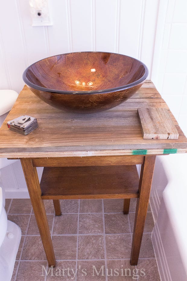 Uma tigela marrom em cima de uma mesa de madeira, com Banheiro e Cerca
