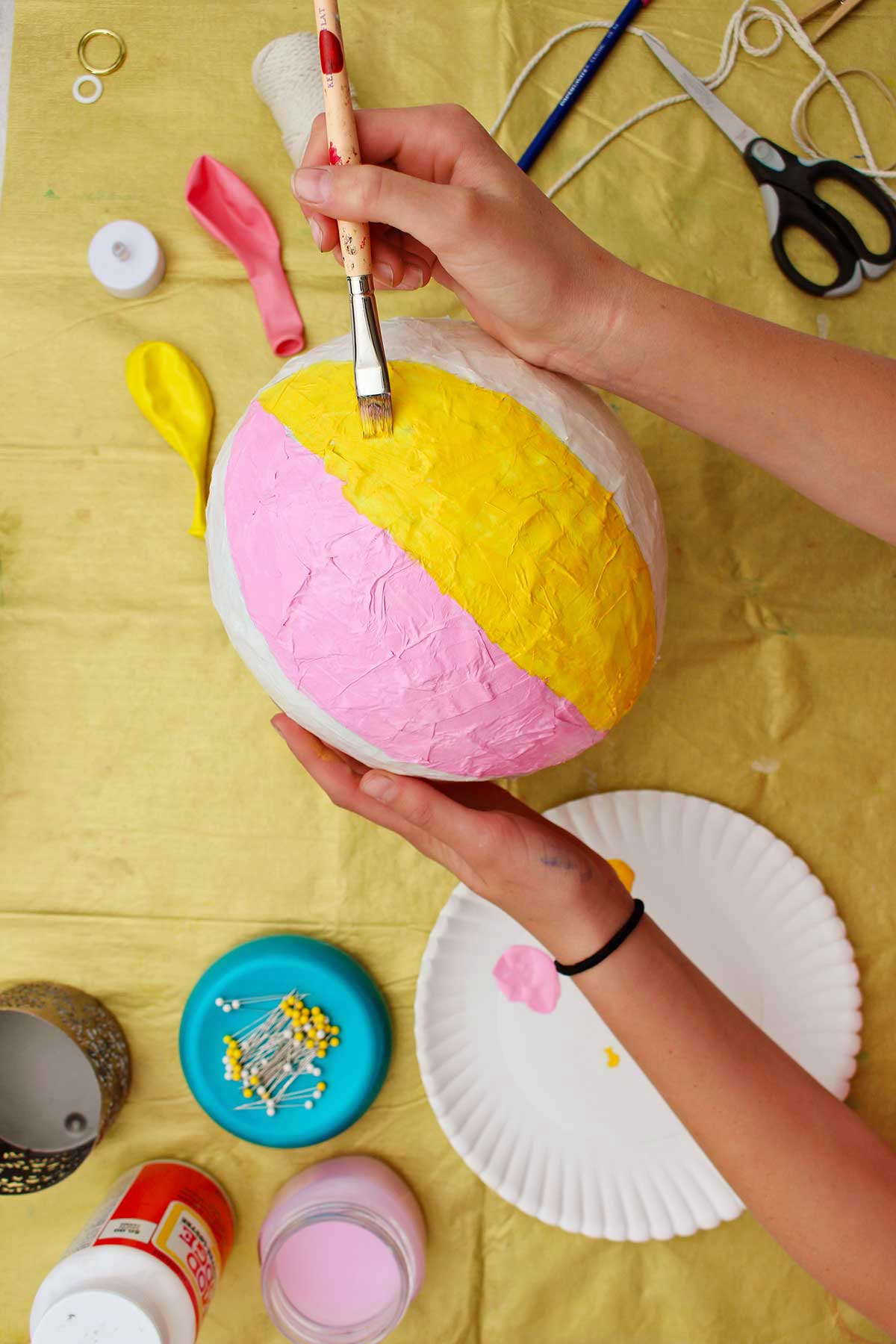 Pessoa pintando uma faixa amarela no seu balão de ar quente.