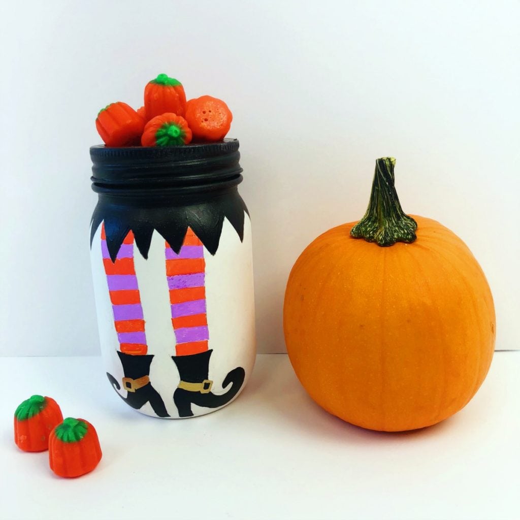 Pernas de bruxa pintadas em um frasco de conserva para o Halloween