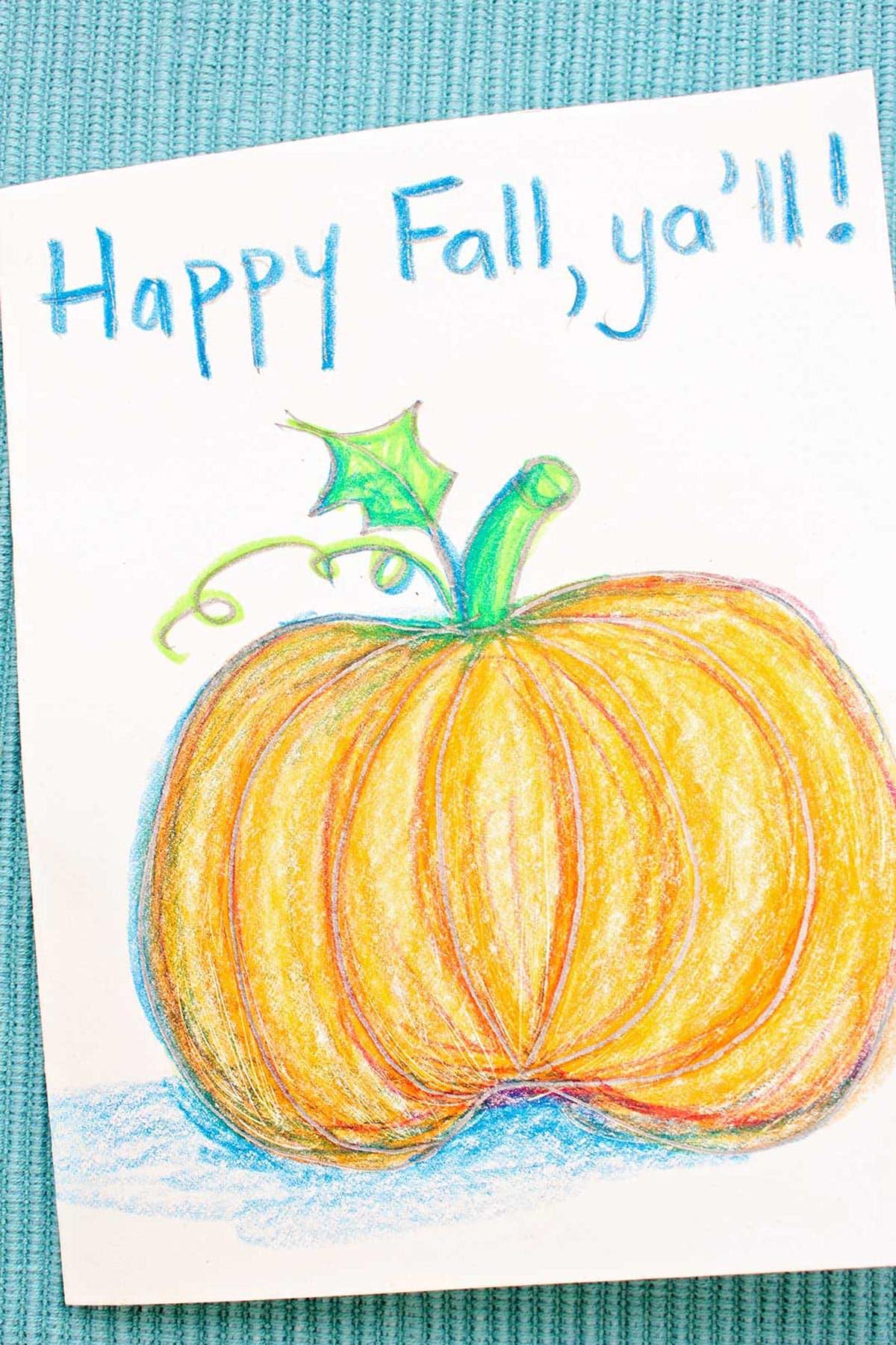Cartão de saudação com um esboço de abóbora colorida descansando sobre um esboço de lápis de jack-o-lantern.