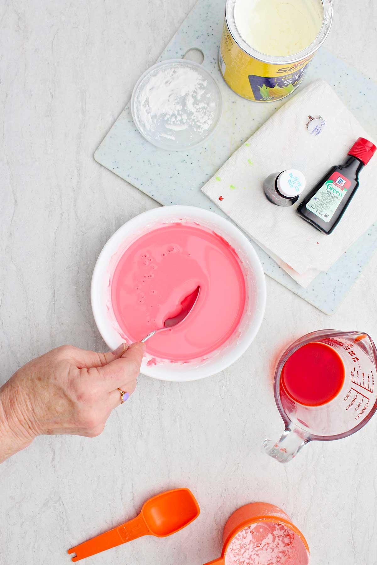 Uma pessoa misturando uma tigela de ingredientes para oobleck rosa.