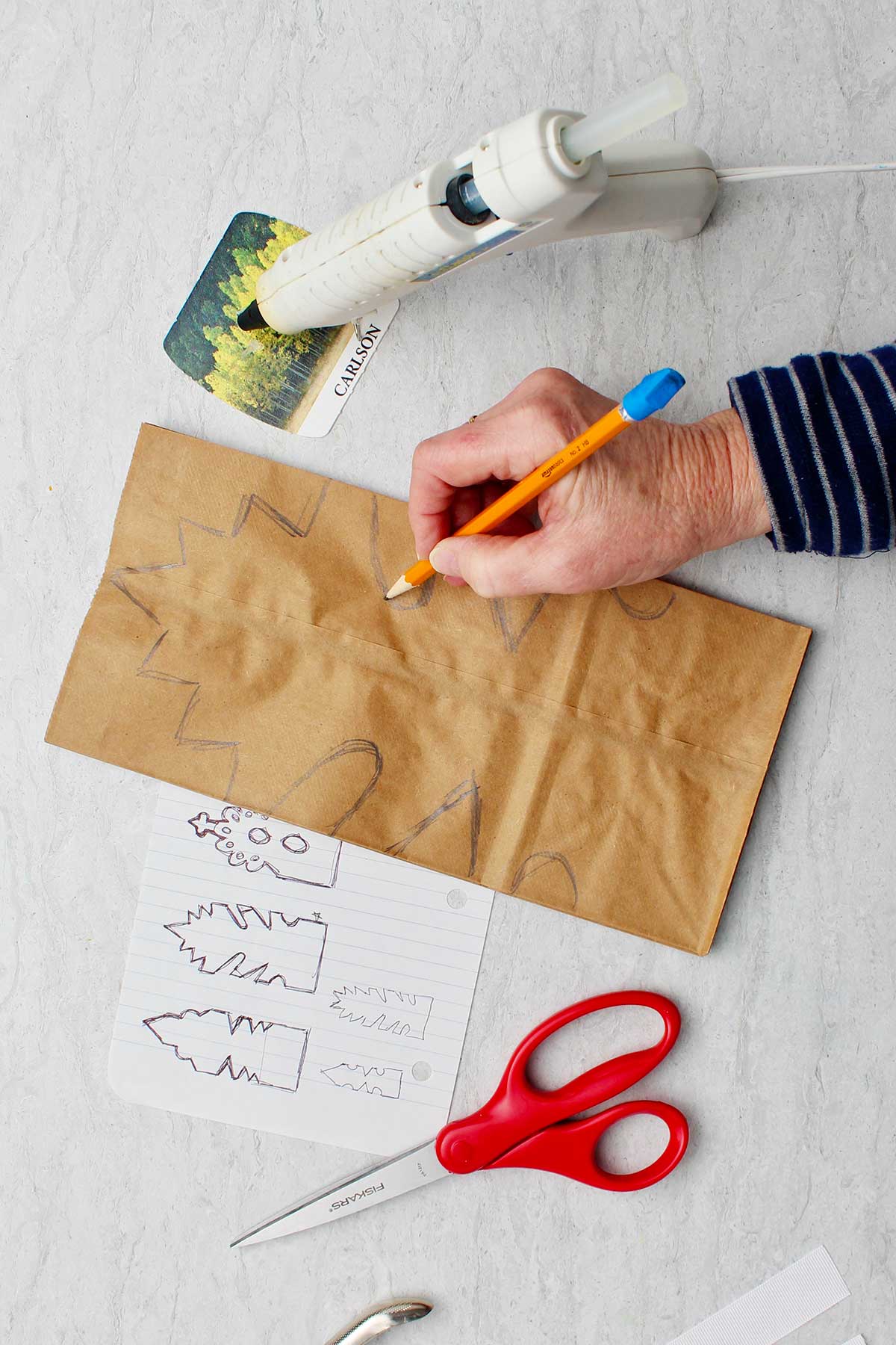 Desenho manual em estêncil em sacos de papel marrons.