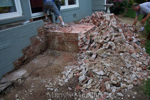 Demolindo degrau de tijolo e escadas na frente da casa