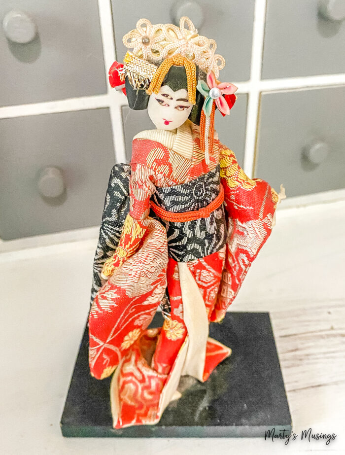 Boneca japonesa em pedestal