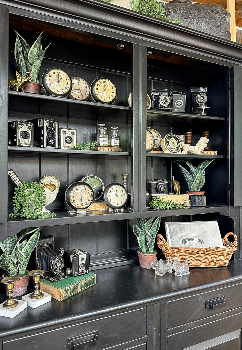 Explore my vintage booth from the Lucketts Spring Market. It's among the trendiest vintage markets on the East Coast! #vintage #vintagedecor painted dark hutch, vintage alarm clocks