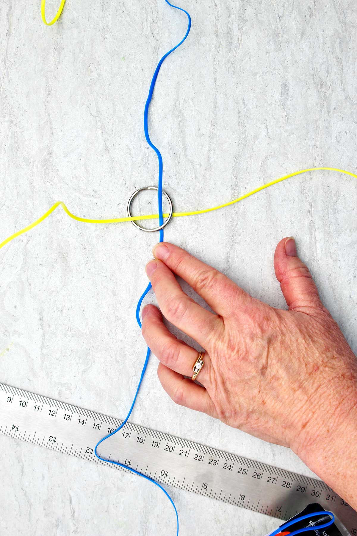 Tecendo um chaveiro boondoggle amarelo e azul.