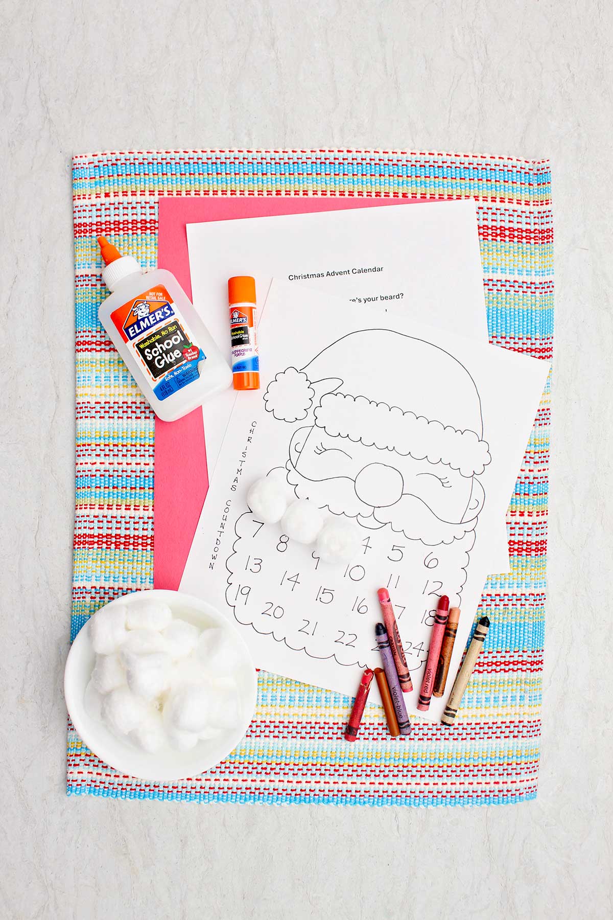 Materiais necessários para um calendário de contagem regressiva do Papai Noel. Um imprimível do Papai Noel, bolinhas de algodão, cola e lápis de cor.
