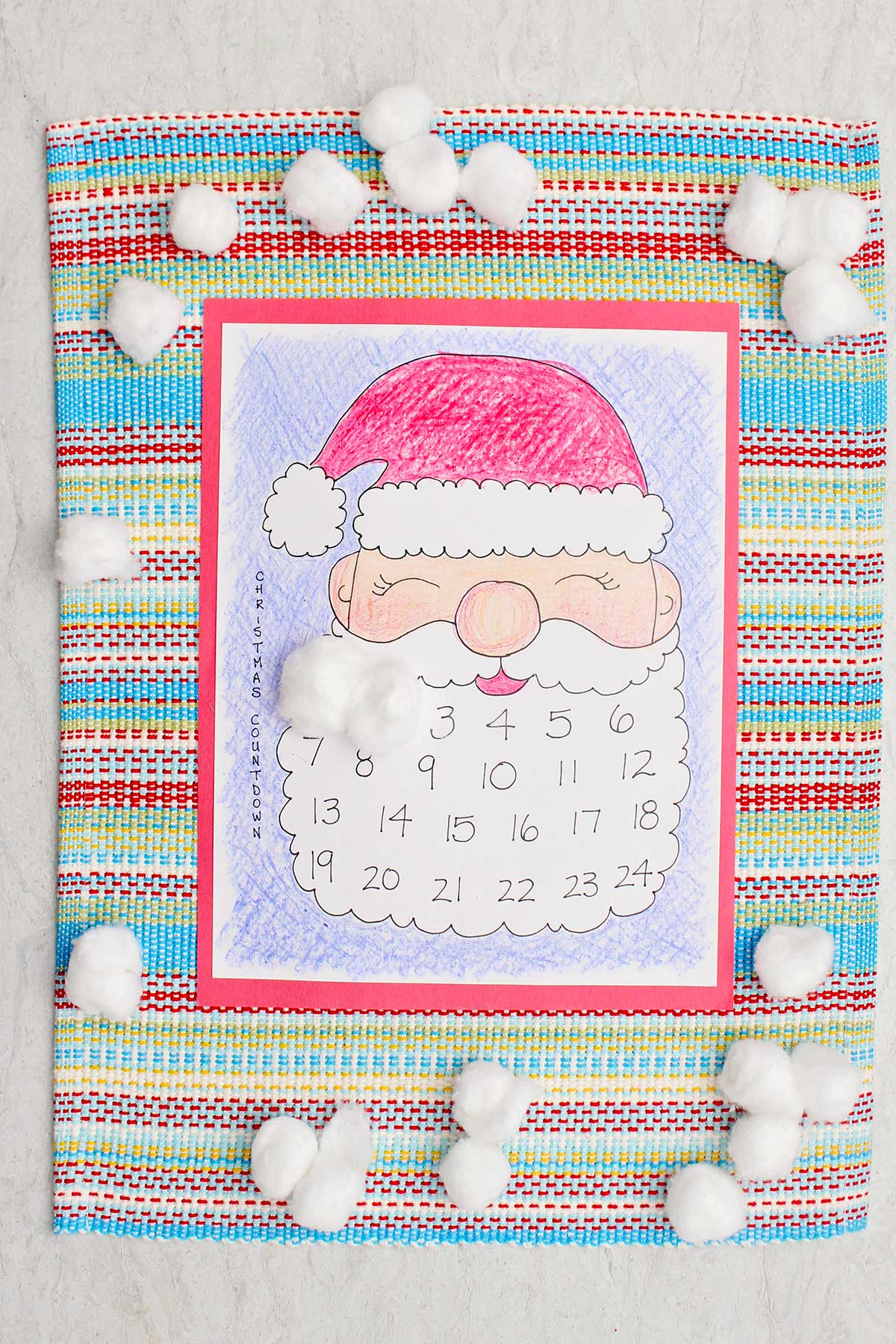 Um calendário do Papai Noel colorido impresso com os dias um e dois cobertos por uma bolinha de algodão na barba do Papai Noel.