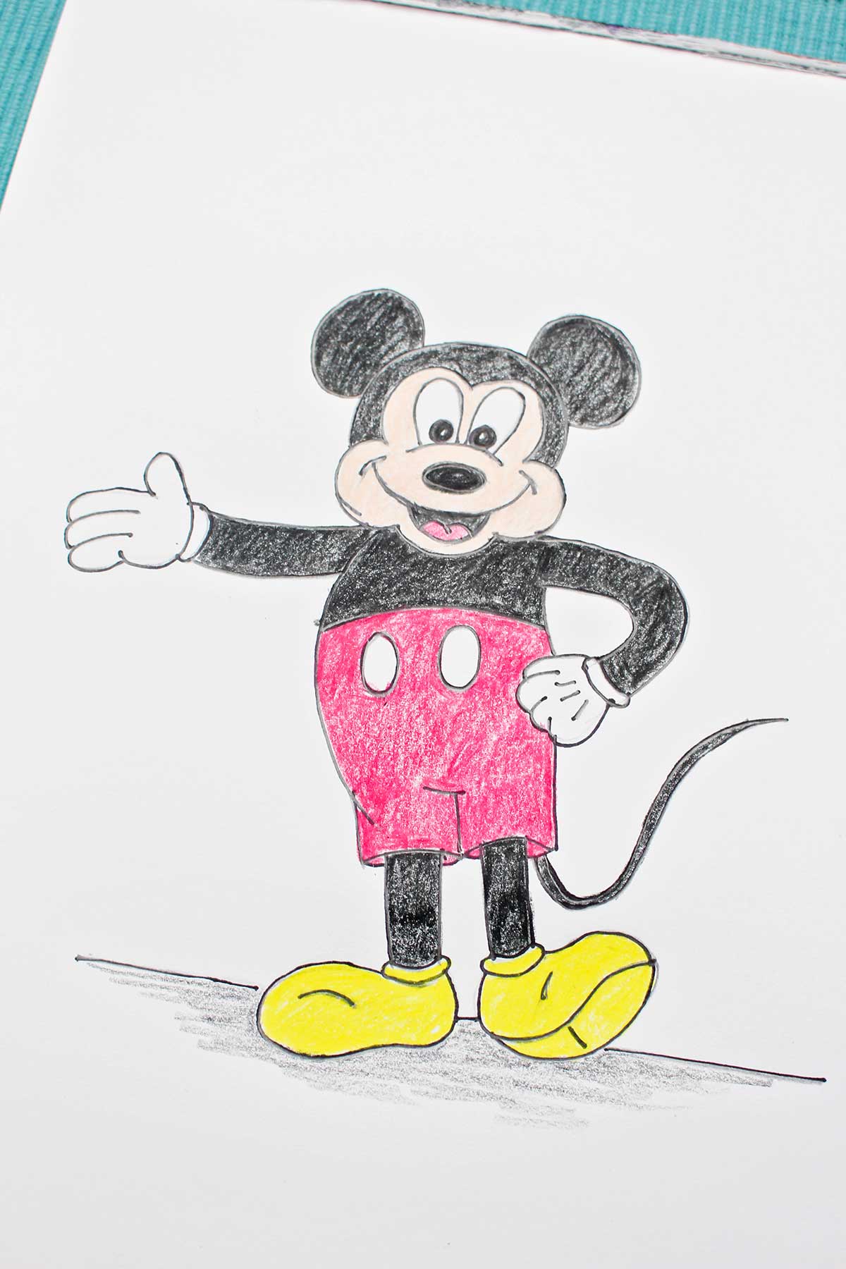 Um esboço completo e colorido do Mickey Mouse com sua mão na cintura e o outro braço para fora.