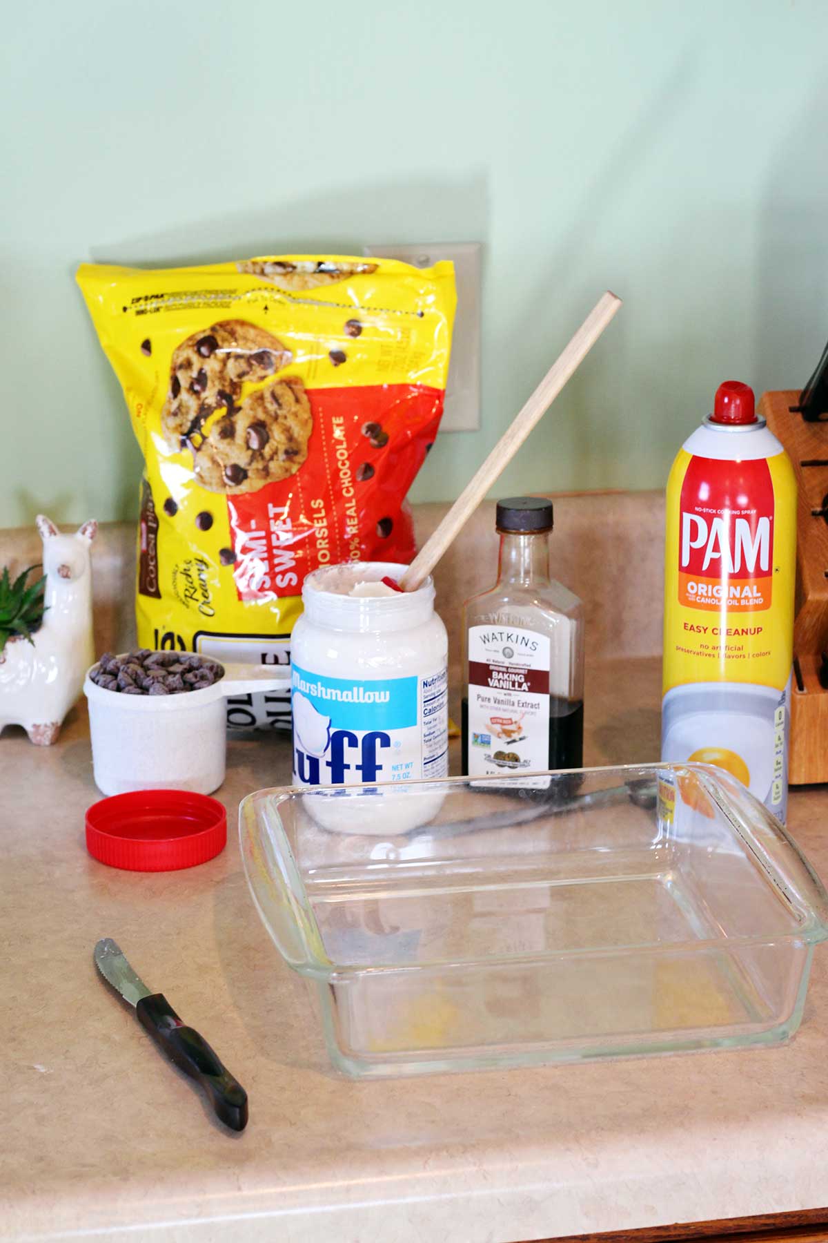 Ingredientes para o fudge e uma forma de vidro 8x8 sobre um balcão.