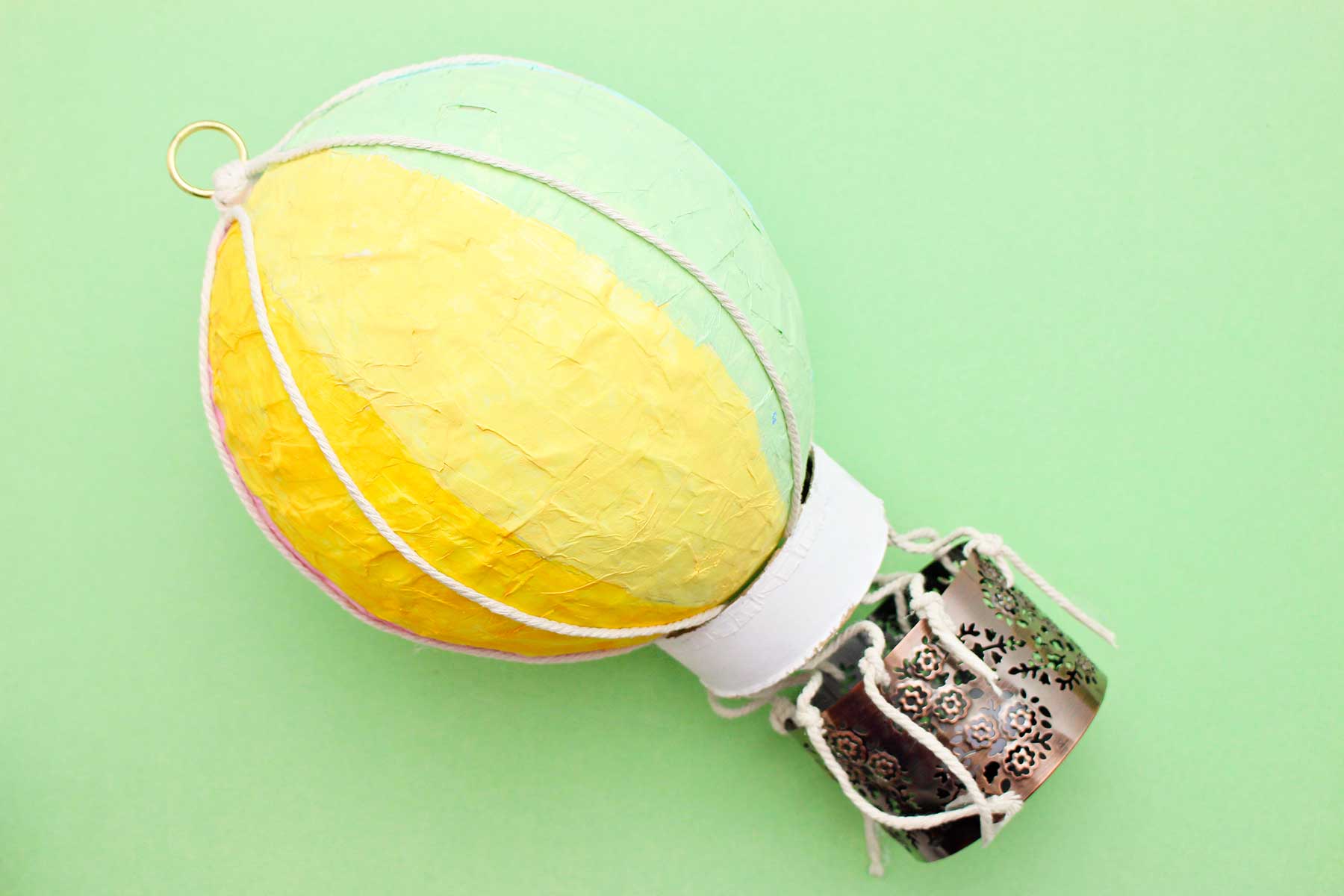 Um balão de ar quente de papel machê contra um fundo verde.