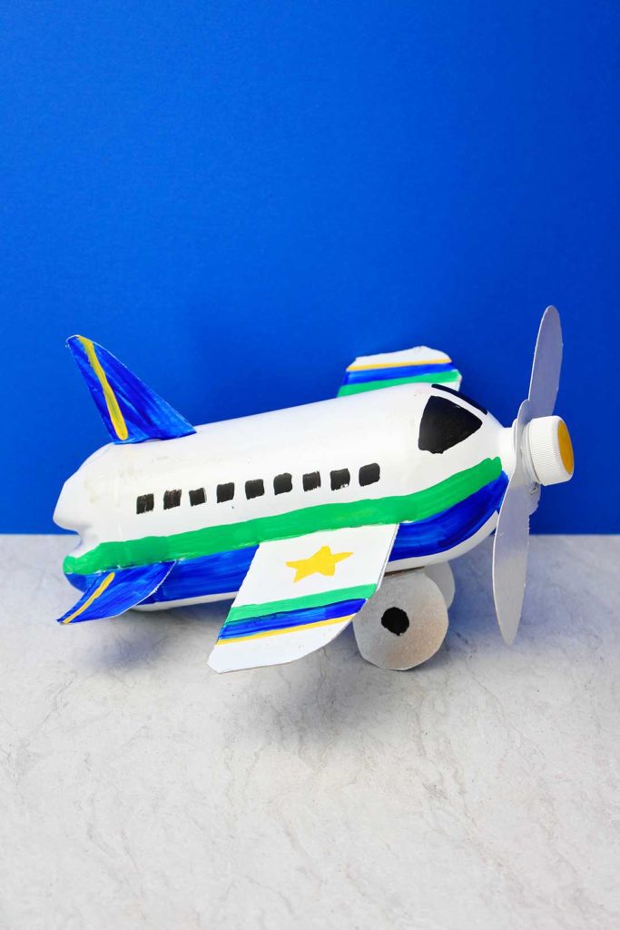 Artesanato em garrafa de avião totalmente pintado e concluído contra um fundo azul.