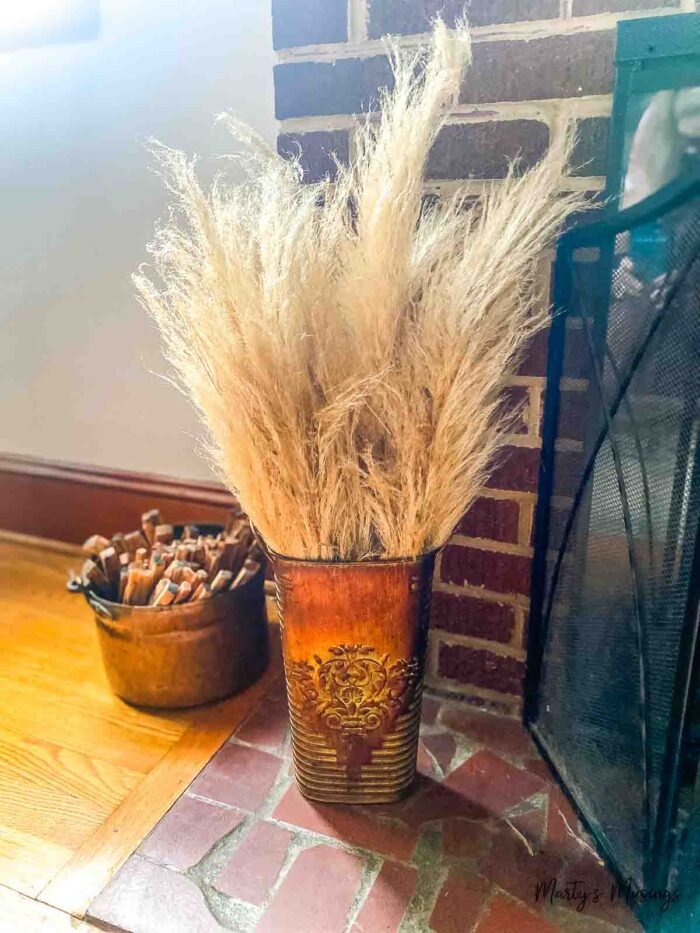 Vaso de cobre cheio de talos secos de capim-dos-pampas