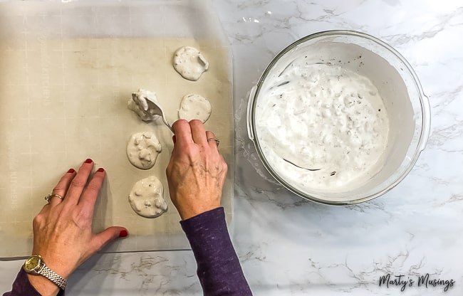 mulher colocando Biscoitos da Ressurreição de Páscoa sobre papel manteiga