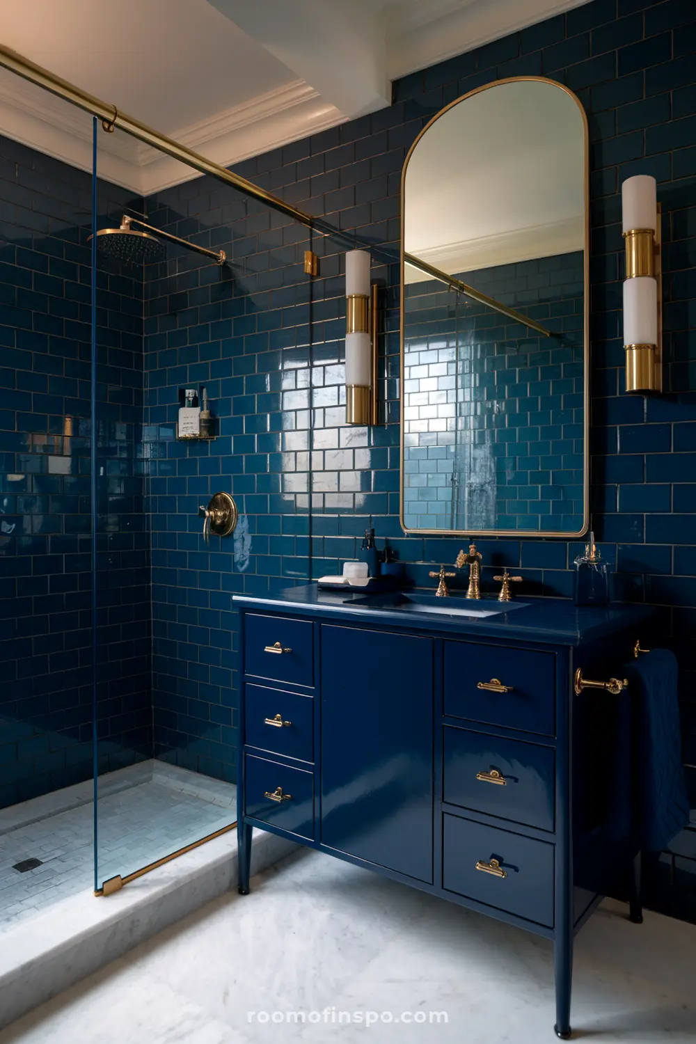 Um banheiro neutro com paredes bege e um backsplash de azulejos azul sombrio atrás da vaidade, iluminado por uma iluminação suave.