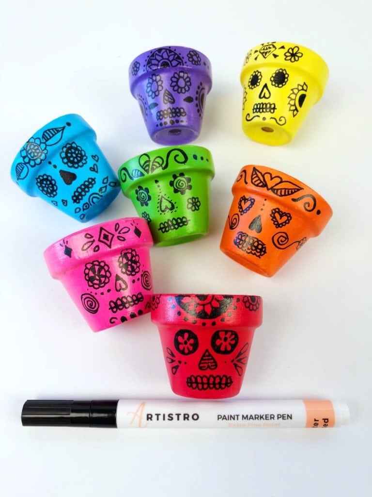 Desenhando caveiras mexicanas em mini vasos de flores com marcador de tinta
