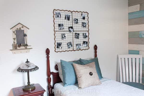 quarto pequeno com parede branca e parede de tábuas com cama de casal