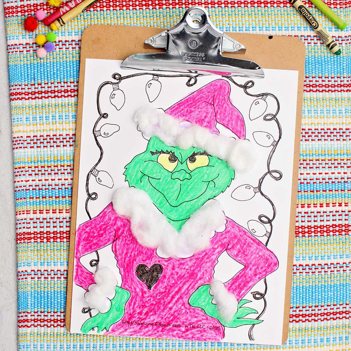 Página de colorir do Grinch completa com acentos de bolinhas de algodão fixados em um clipboard.