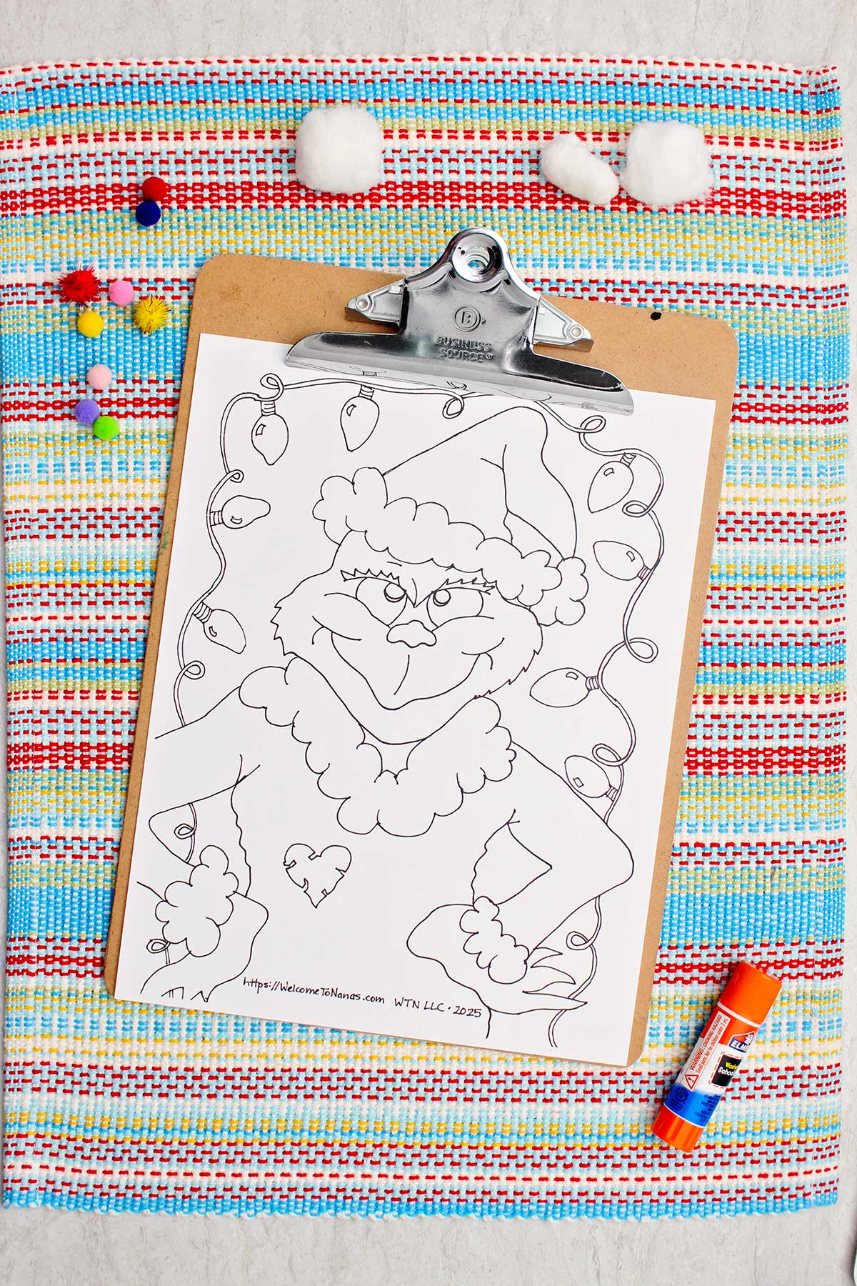 Página de colorir do Grinch não colorida em uma prancheta.