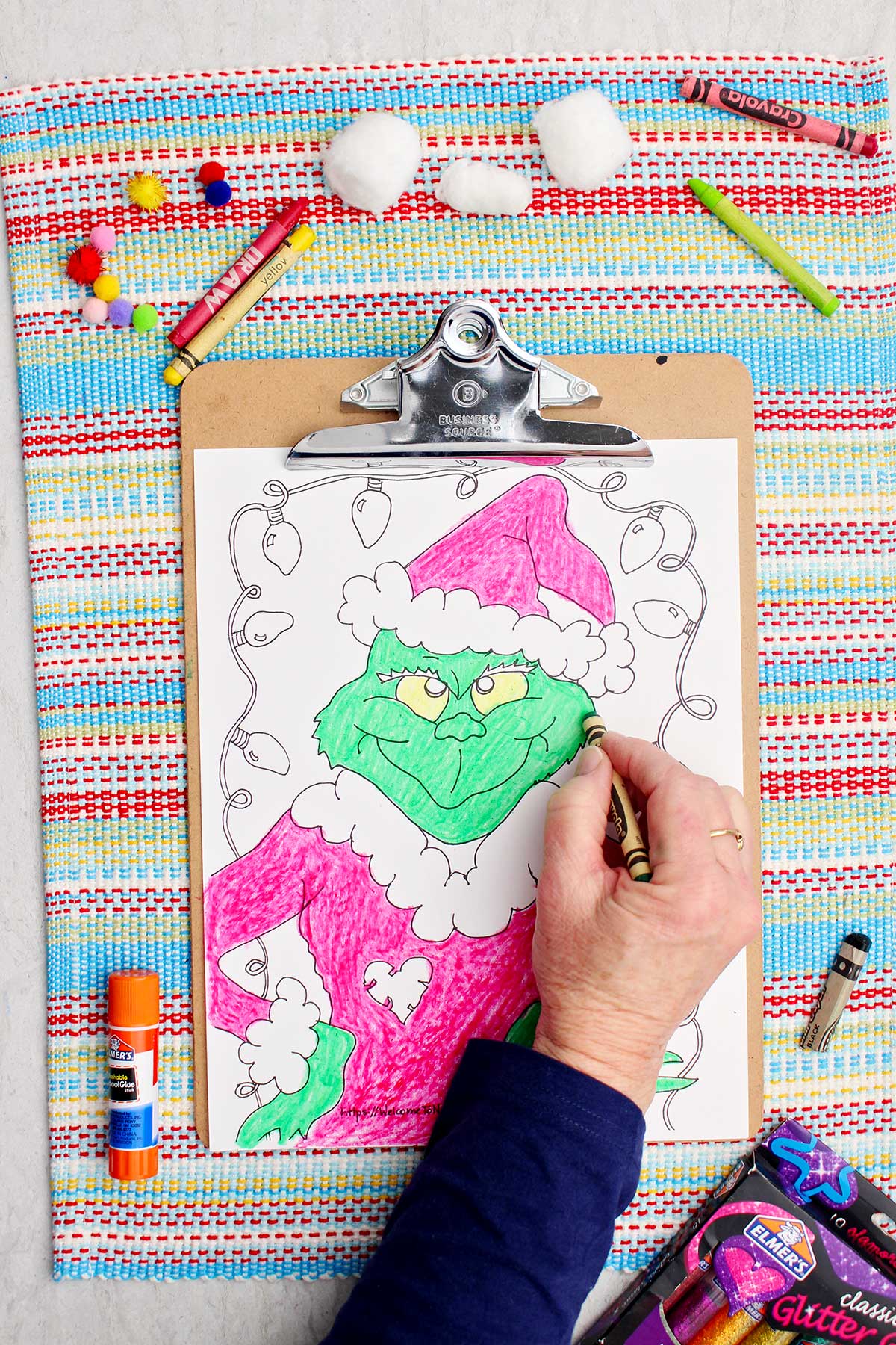 Pessoa colorindo o Grinch de verde na página de colorir.