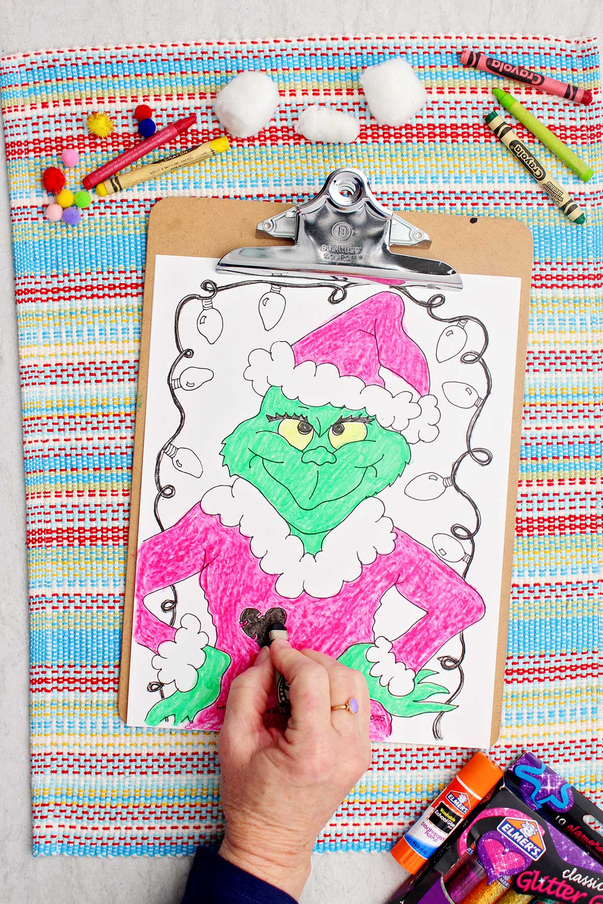 Pessoa colorindo coração no casaco na página de colorir do Grinch.