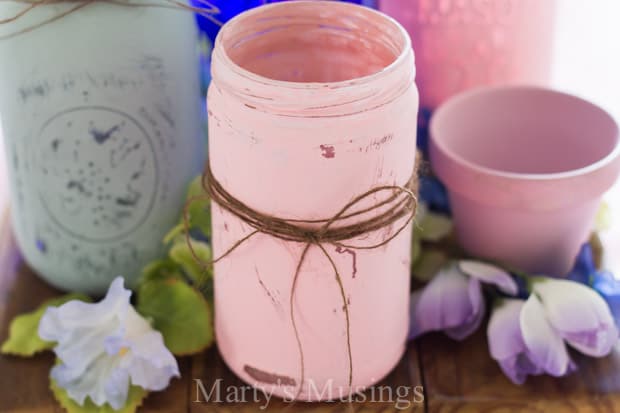 Uma xícara de café sobre uma mesa, com um pote mason jar