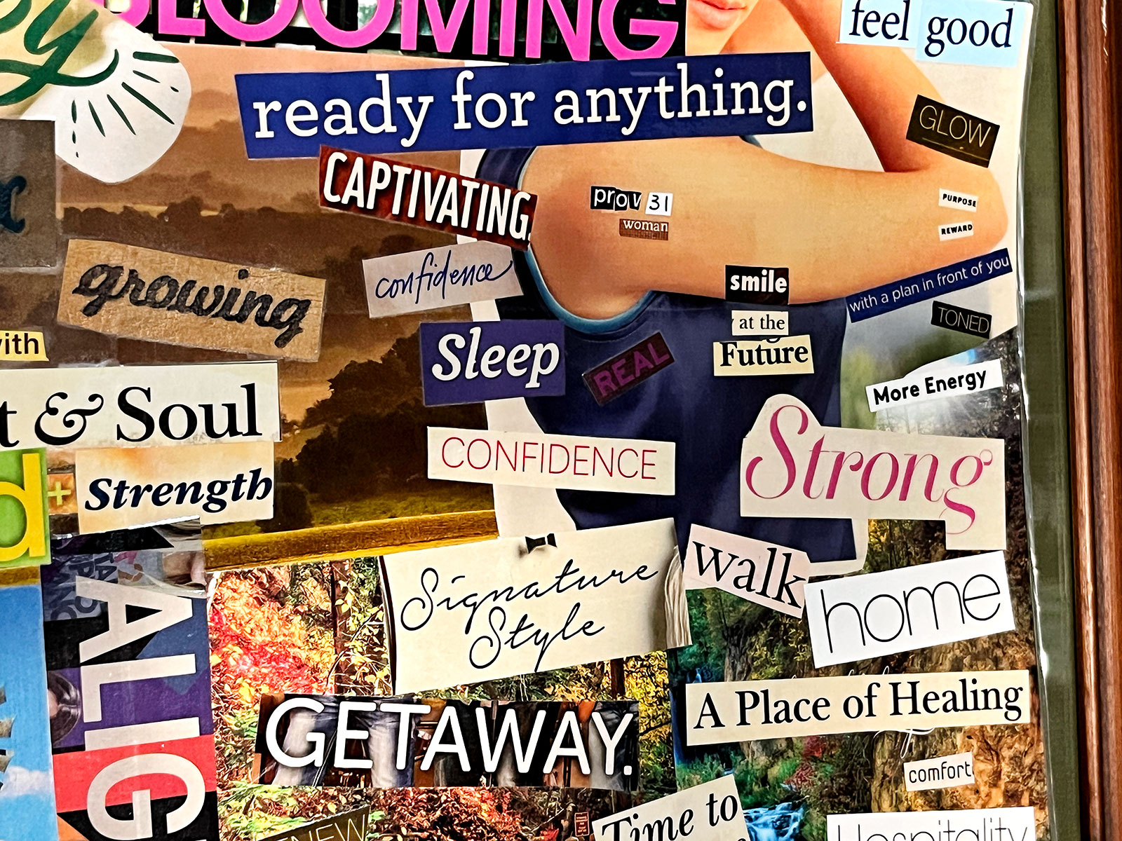 Uma visão detalhada de um mural de visão feito com recortes de revistas, com texto em negrito e imagens coloridas brilhantes.