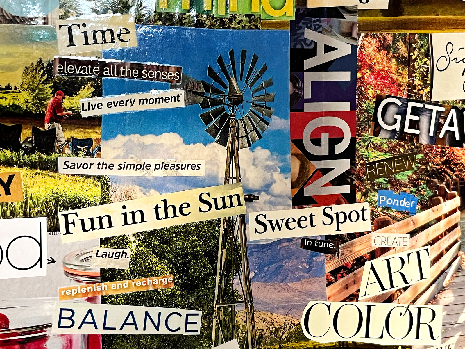 Um close de um quadro de visão feito com recortes de revista, com texto em negrito e imagens coloridas brilhantes.