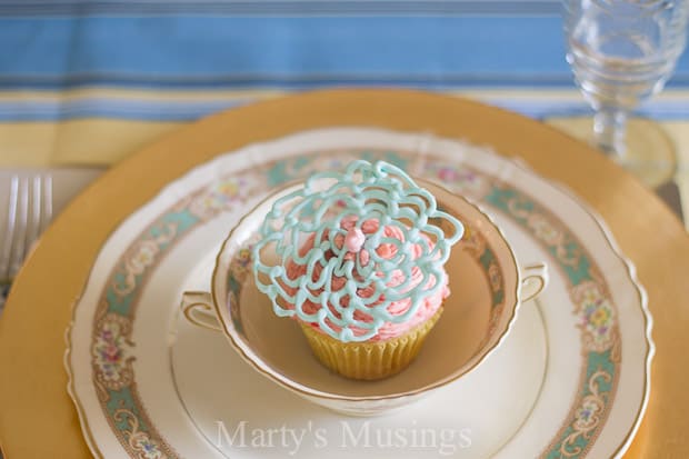 Uma mesa com um bolo sobre um prato, com cupcake