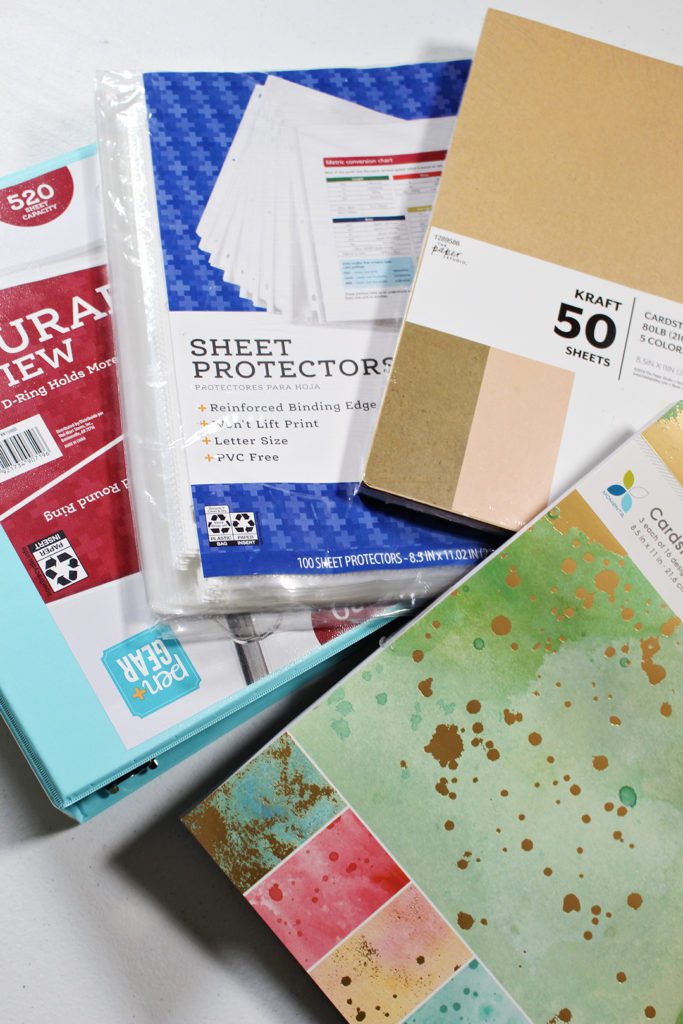 Protetores de folhas, papel de scrapbook, papel cartão e um fichário.