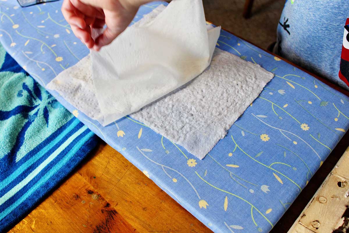 Retirando uma toalha de papel de uma página de polpa de papel reciclado.