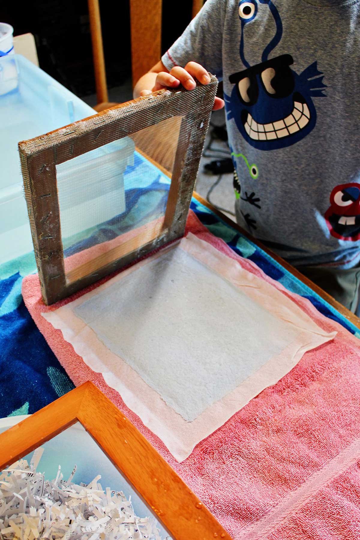 Levantando a moldura de um pedaço molhado de papel caseiro.