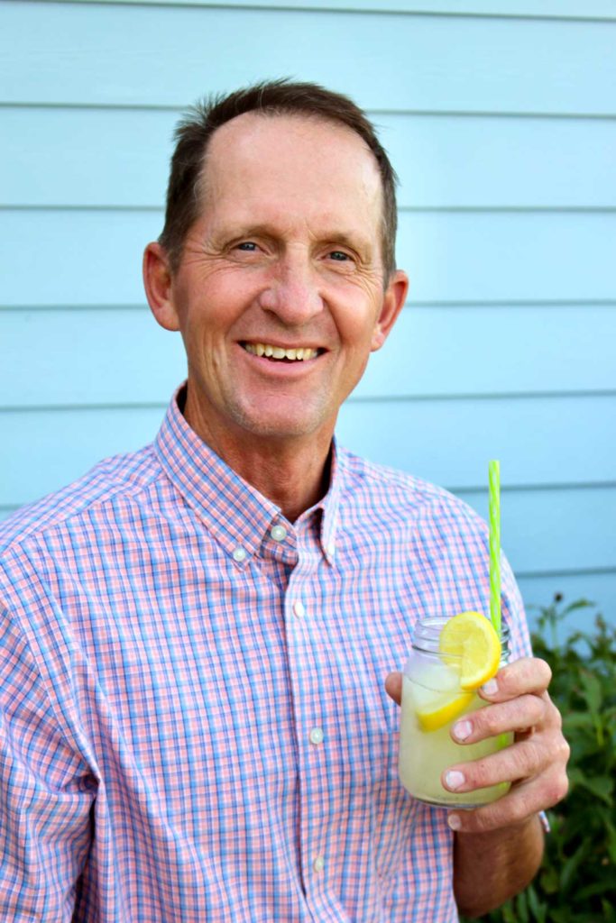 Um homem segurando um copo de limonada ao ar livre