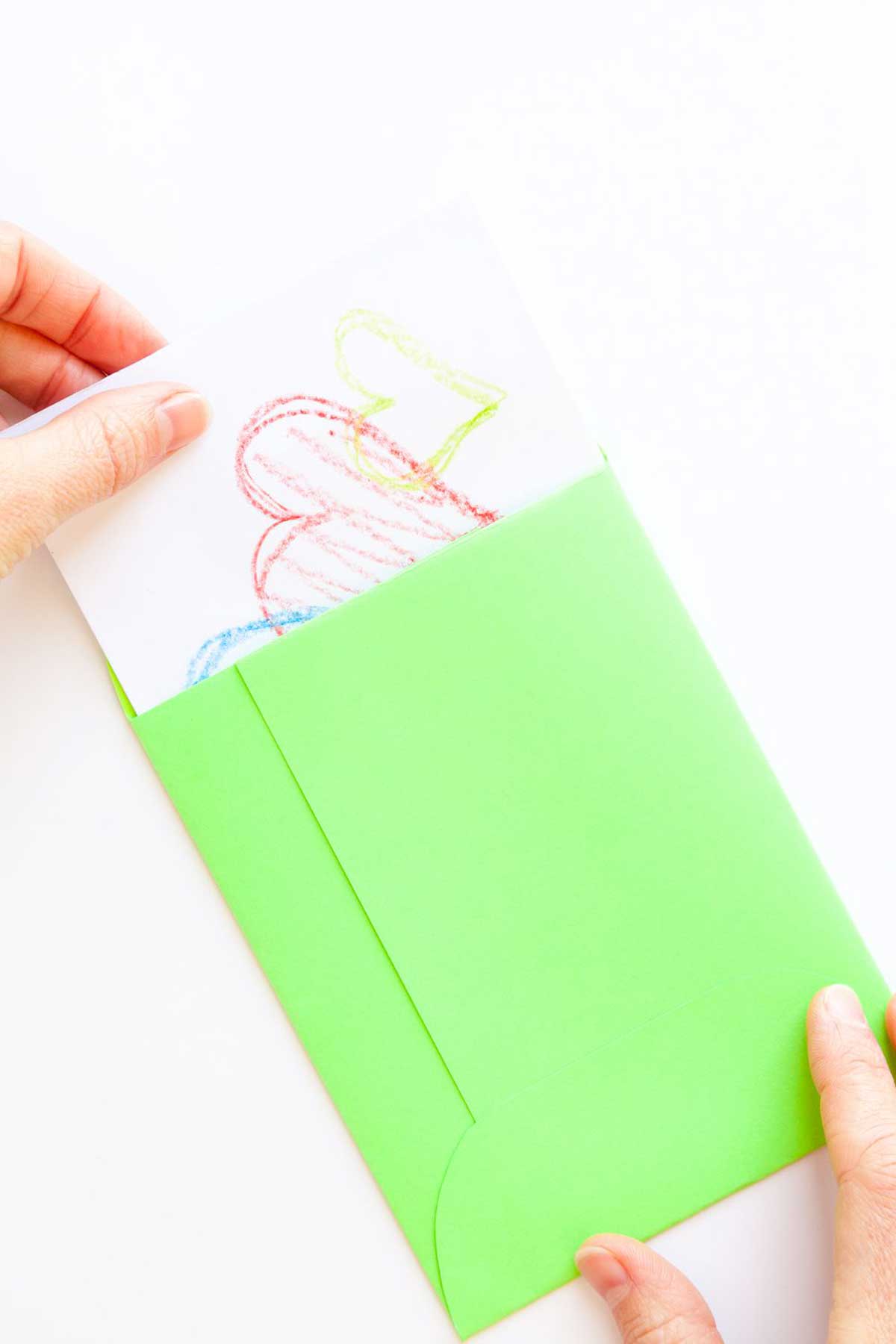Puxando um cartão com corações de um envelope verde.