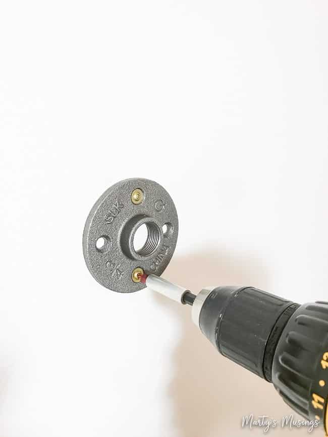 Fixando a flange na parede com chave de fenda para a moldura flutuante