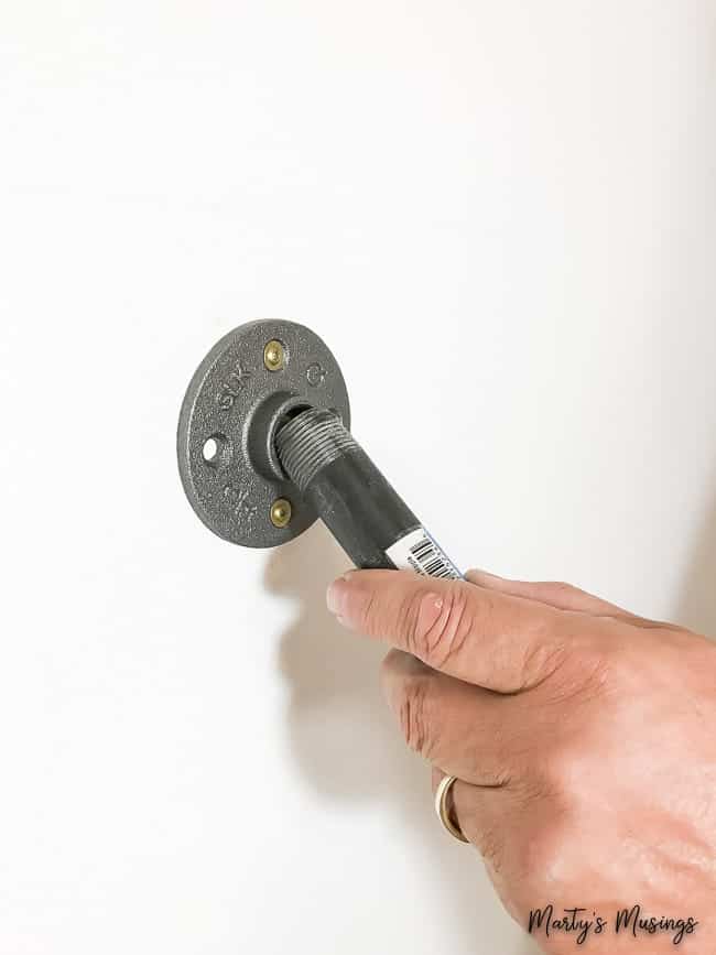 Fixando o tubo à flange na parede para a moldura flutuante
