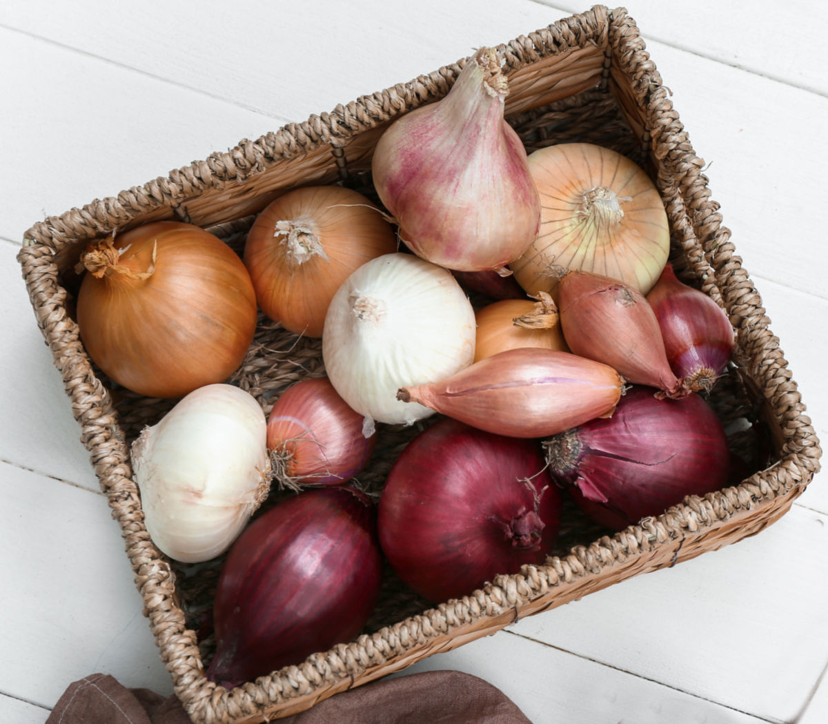 Uma cesta cheia de chalotas e outros alliums.