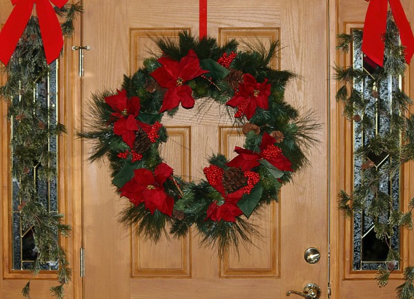 Guirlanda de Natal Tradicional com laços vermelhos na porta da frente.