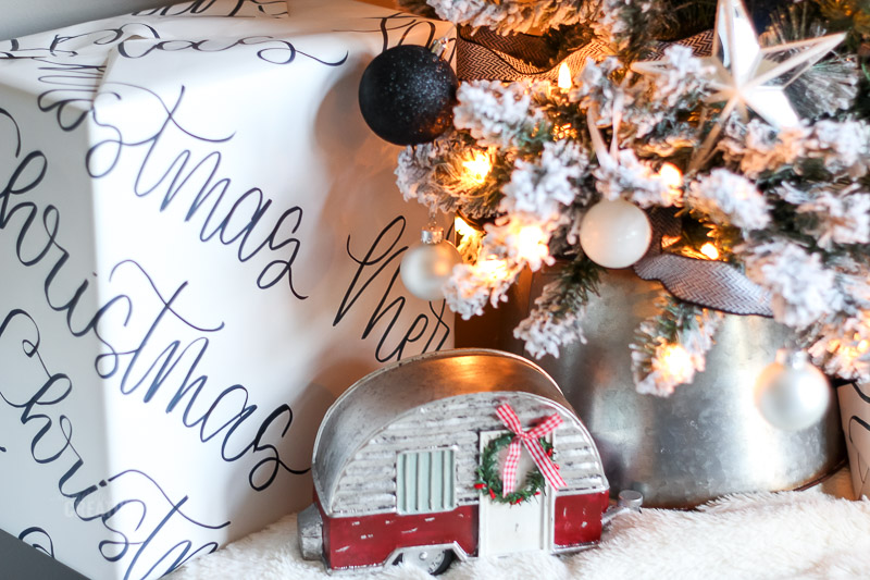 trailer rústico de mesa ao lado da base da árvore de Natal e presentes embrulhados