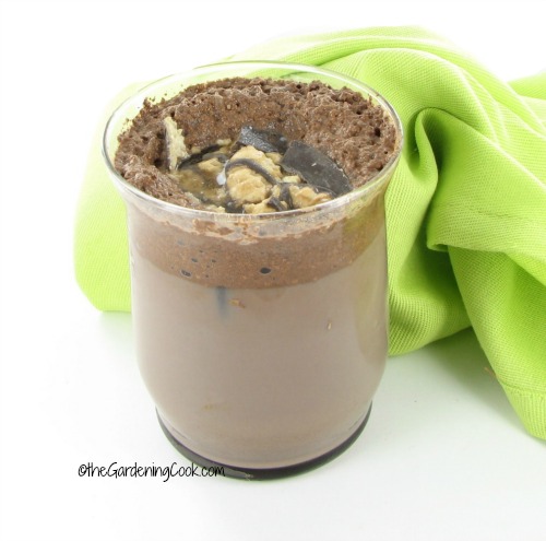 Leite com chocolate com sabor de café e cookies em um copo com um guardanapo verde.