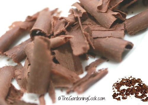 Raspas de chocolate e chocolate ralado sobre um fundo branco.