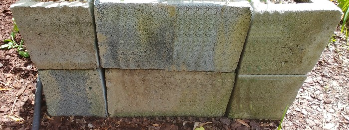 Seção final de uma cama de jardim elevada feita de blocos de concreto.