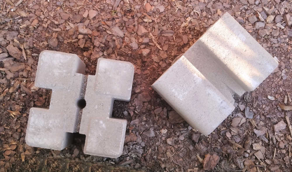 Blocos de parede de concreto no chão, prontos para fazer os suportes de uma cama elevada DIY.